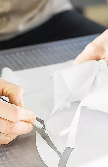 Flexfolie wird mit Skalpell vom Trägerpapier geschnitten